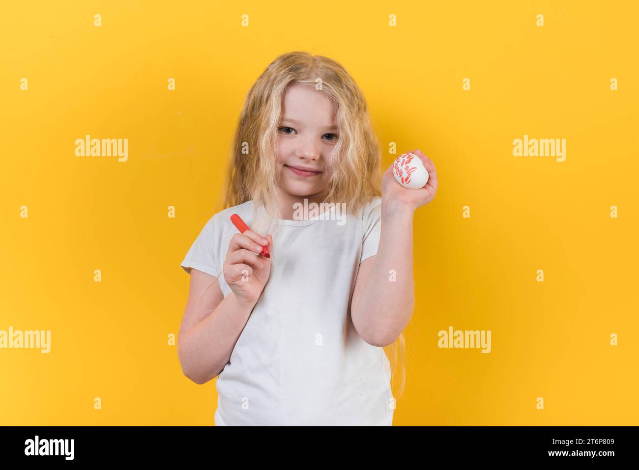 Mädchen, das mit einem bemalten Eierfilzstift steht Stockfoto