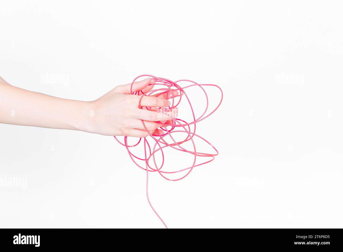 Menschliche Hand mit verwickeltem rotem Draht Stockfoto