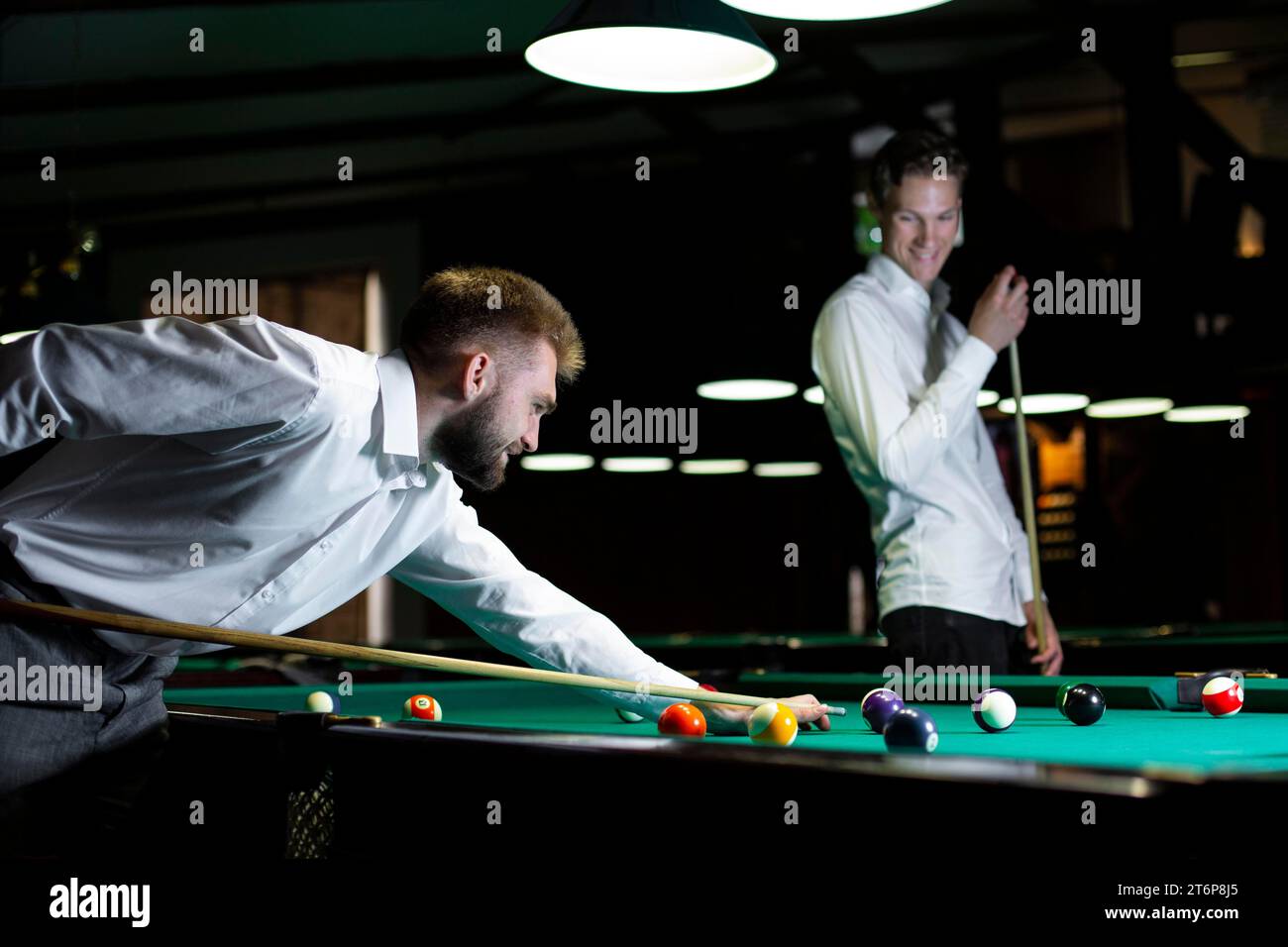 Mittelgroße Jungs spielen zusammen Billard Stockfoto