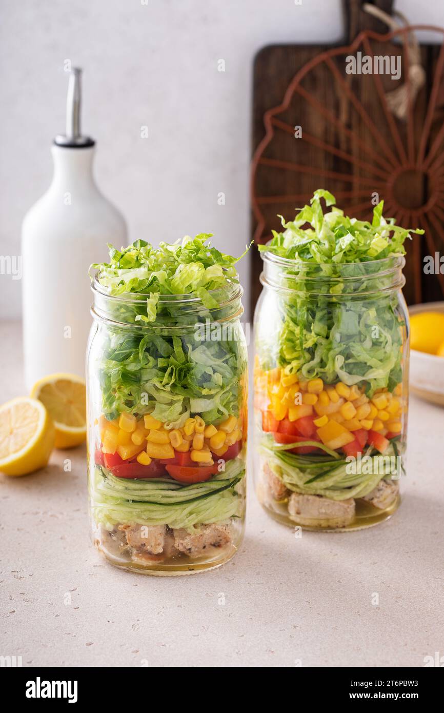 Hühnchen und Gemüsesalat in einem Glas, Mahlzeit vorbereiten für gesundes Mittagessen unterwegs für Arbeit oder Schule Stockfoto