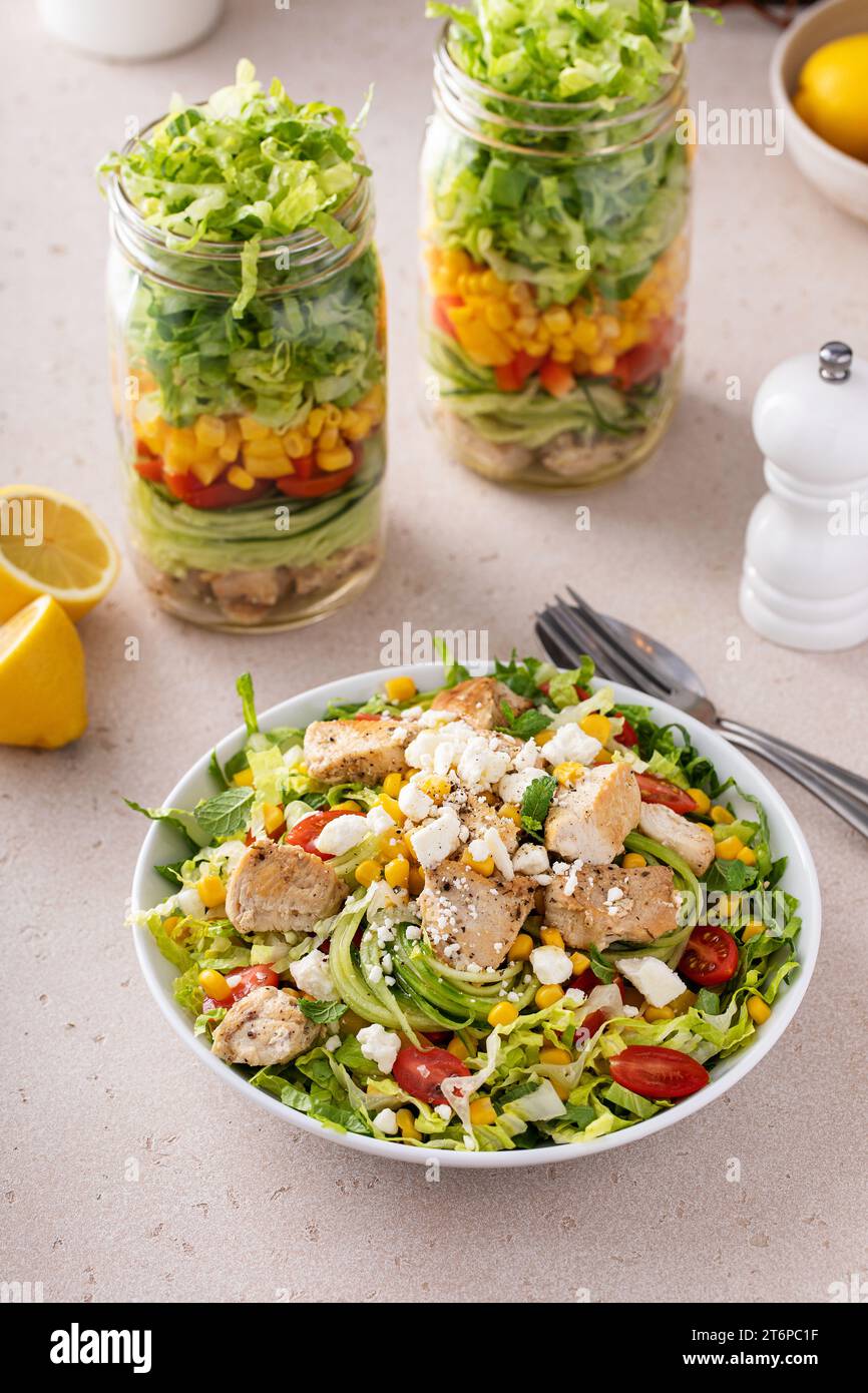 Hühnchen und Gemüsesalat in einem Glas, Mahlzeit vorbereiten für gesundes Mittagessen unterwegs für Arbeit oder Schule Stockfoto