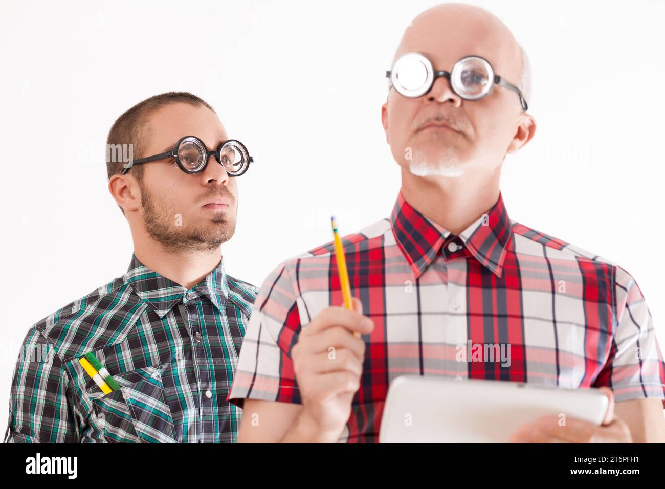 Älterer Mann mit Tablette und jünger mit Bleistiften, schrullig Stockfoto