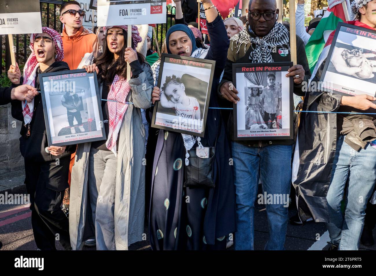 11. November 2023, London, Großbritannien. Hunderttausende von Menschen marschieren durch das Zentrum Londons, um gegen die anhaltende Bombardierung des Gazastreifens durch Israel zu protestieren. Die Organisatoren der Demonstration, der palästinensischen Solidaritätskampagne, fordern einen sofortigen Waffenstillstand. Im Bild: Demonstranten zeigen Fotos von Kindern, die durch den israelischen Bombardement auf Gaza getötet wurden. Stockfoto