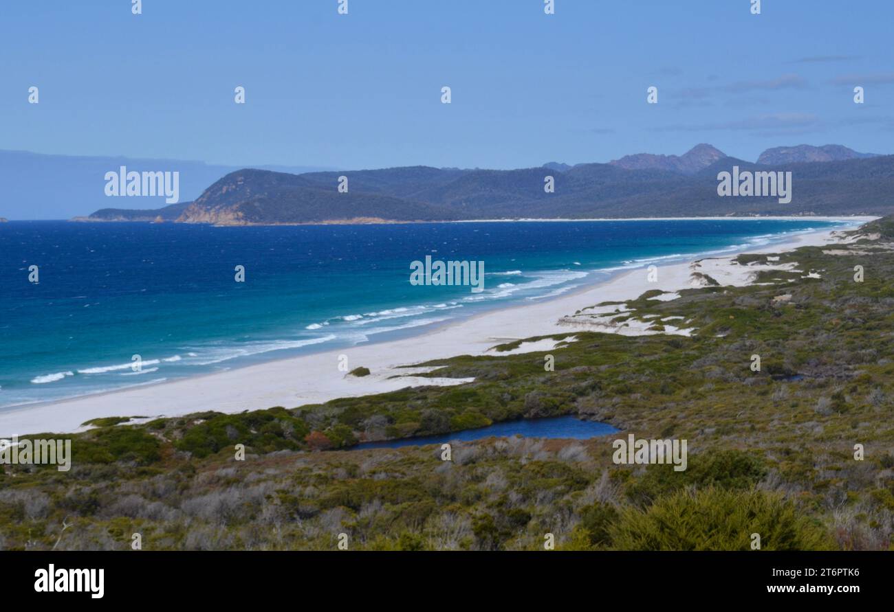 Weite weiße Sandstrände entlang der Freycinet Peninsula in Tasmanien sind malerische, unberührte weiße Sanddünen mit Meereswellen Stockfoto