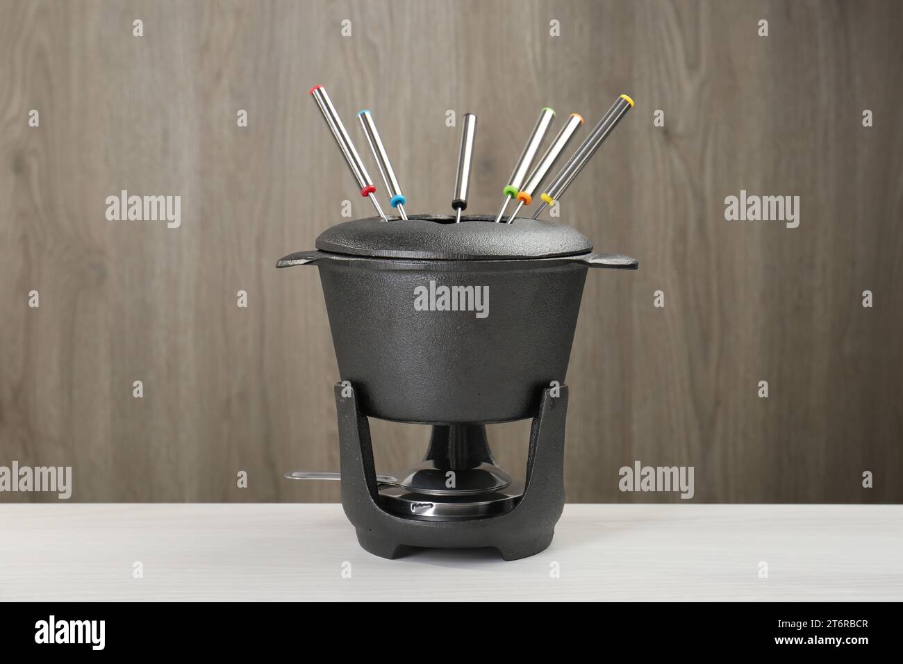 Fondueset auf weißem Holztisch. Küchenausstattung Stockfoto