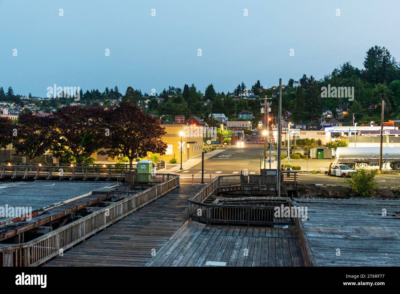 In der kleinen Stadt Astoria, Oregon, erleuchten die Lichter der Stadt in der Abenddämmerung, von einem Pier entlang der Uferpromenade des Columbia River aus gesehen. Stockfoto