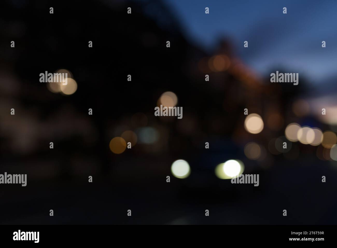 Bokeh Hintergrund von Autos, die nach Sonnenuntergang am Strand entlang fahren, zurück fahren Stockfoto