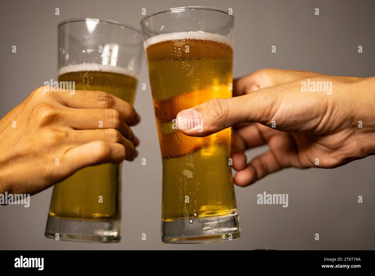 Nahaufnahme von zwei Gläsern Bier in der Hand. Hände Clinking Gläser Bier. Stockfoto