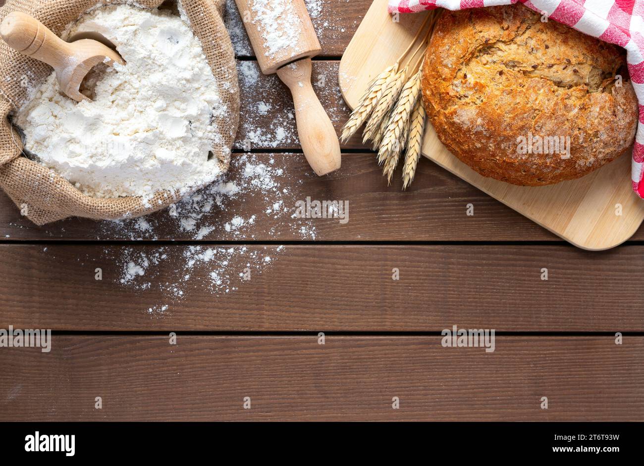 Brot auf Schneidebrett, Mehl und Pin auf hölzernem Hintergrund, Kopierraum Stockfoto