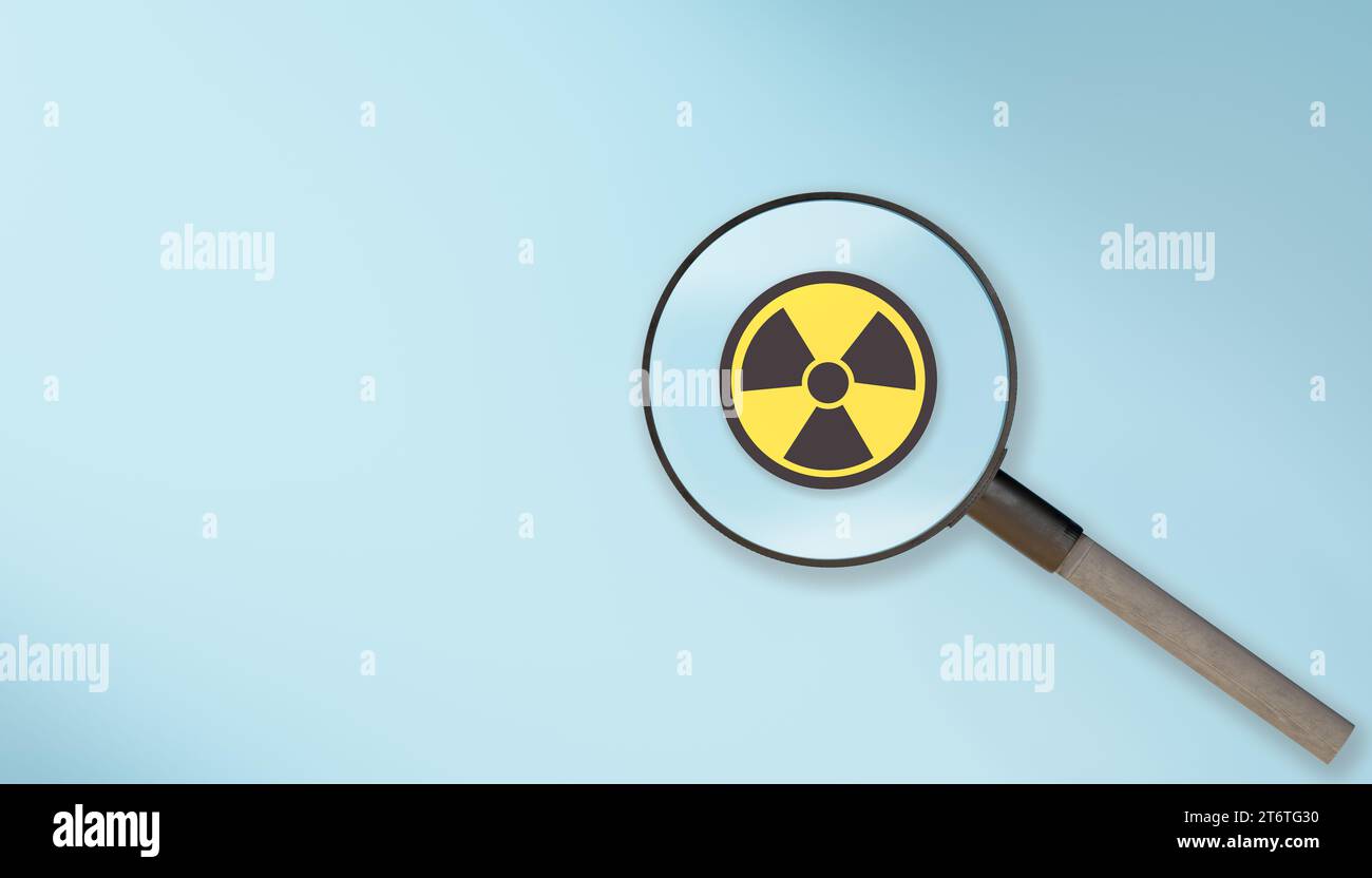 Lupe mit Warnzeichen für Strahlung. Lupe mit Strahlungssymbol. Strahlungssymbol. Achtung, Warnung, Warnsymbol, Vorsicht gefährlicher Betrüger Stockfoto