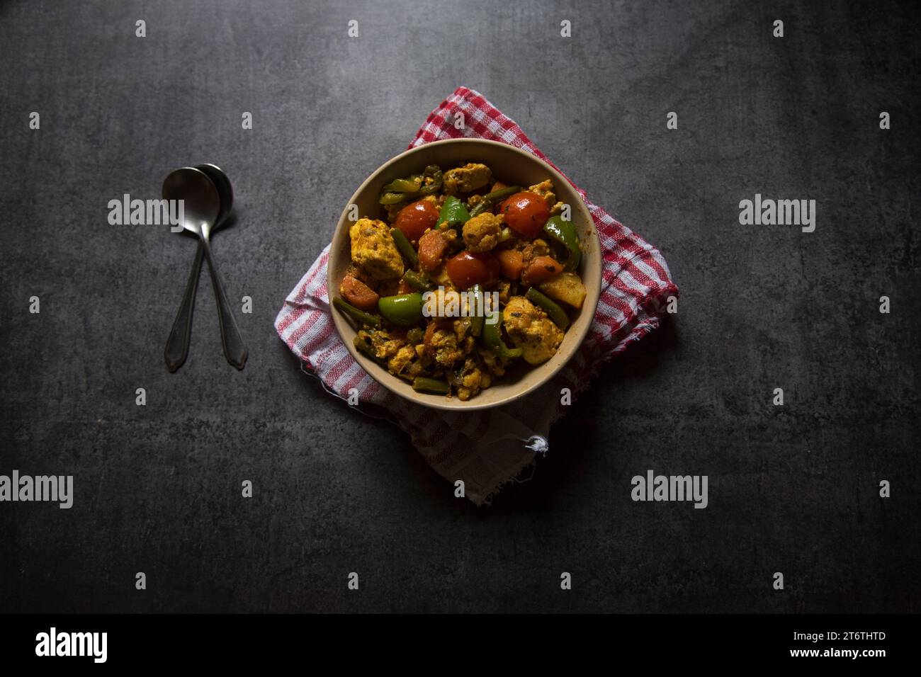 Indisches Hauptgericht gemischtes Gemüse-Curry mit Karotten, Blumenkohl, Bohnen, Paprika und Paneer oder Hüttenkäse in einer Schüssel serviert. Draufsicht Stockfoto