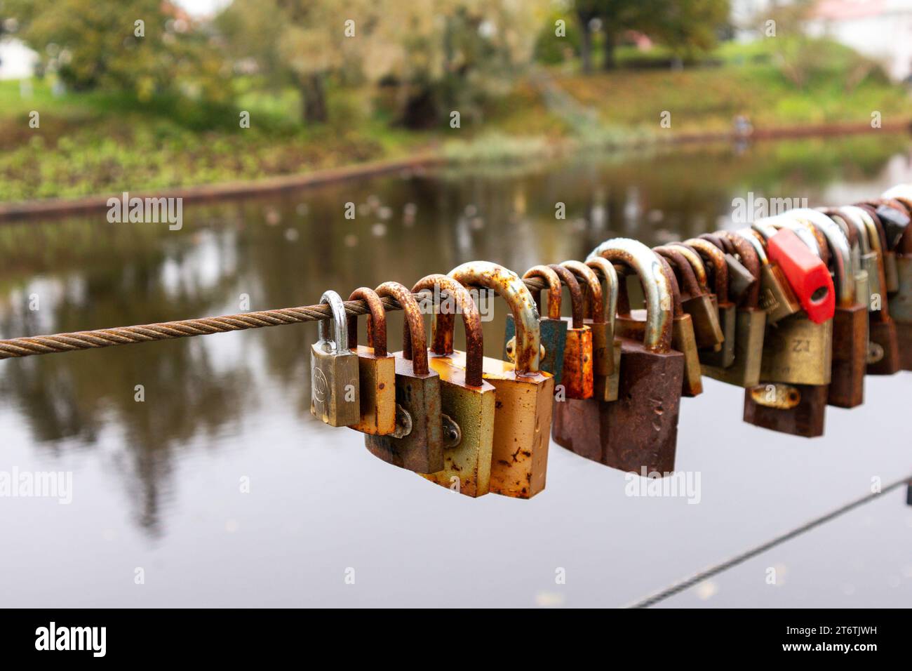 Eine Schnur mit vielen Schlüsseln, die an einem Metallseil mit braunem Aqua-Hintergrund befestigt sind Stockfoto