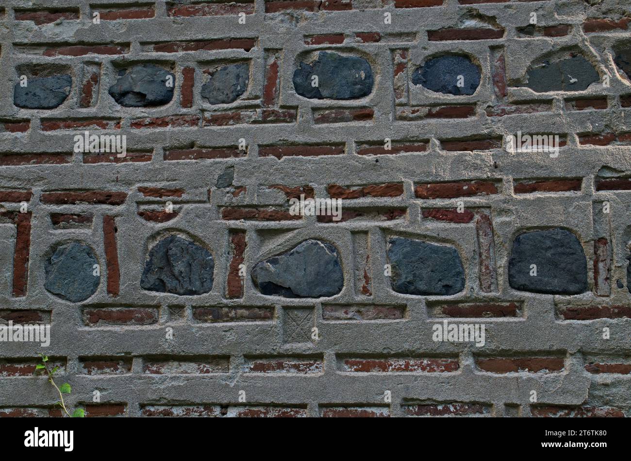 Natürliches Muster für Hintergründe und Tapeten durch die Dekoration einer roten Ziegelwand mit Steinblöcken, die mit Beton befestigt sind, Dragalevski Kloster Stockfoto