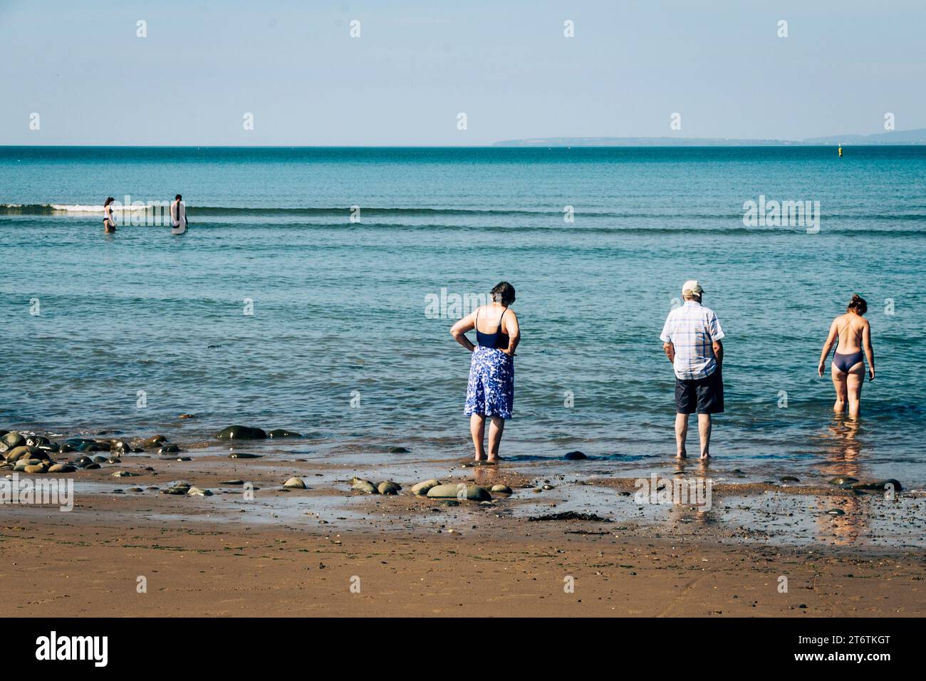 Die Menschen paddeln in den flachen Gewässern von Abersoch in Gwynedd, Nordwales in Großbritannien Stockfoto