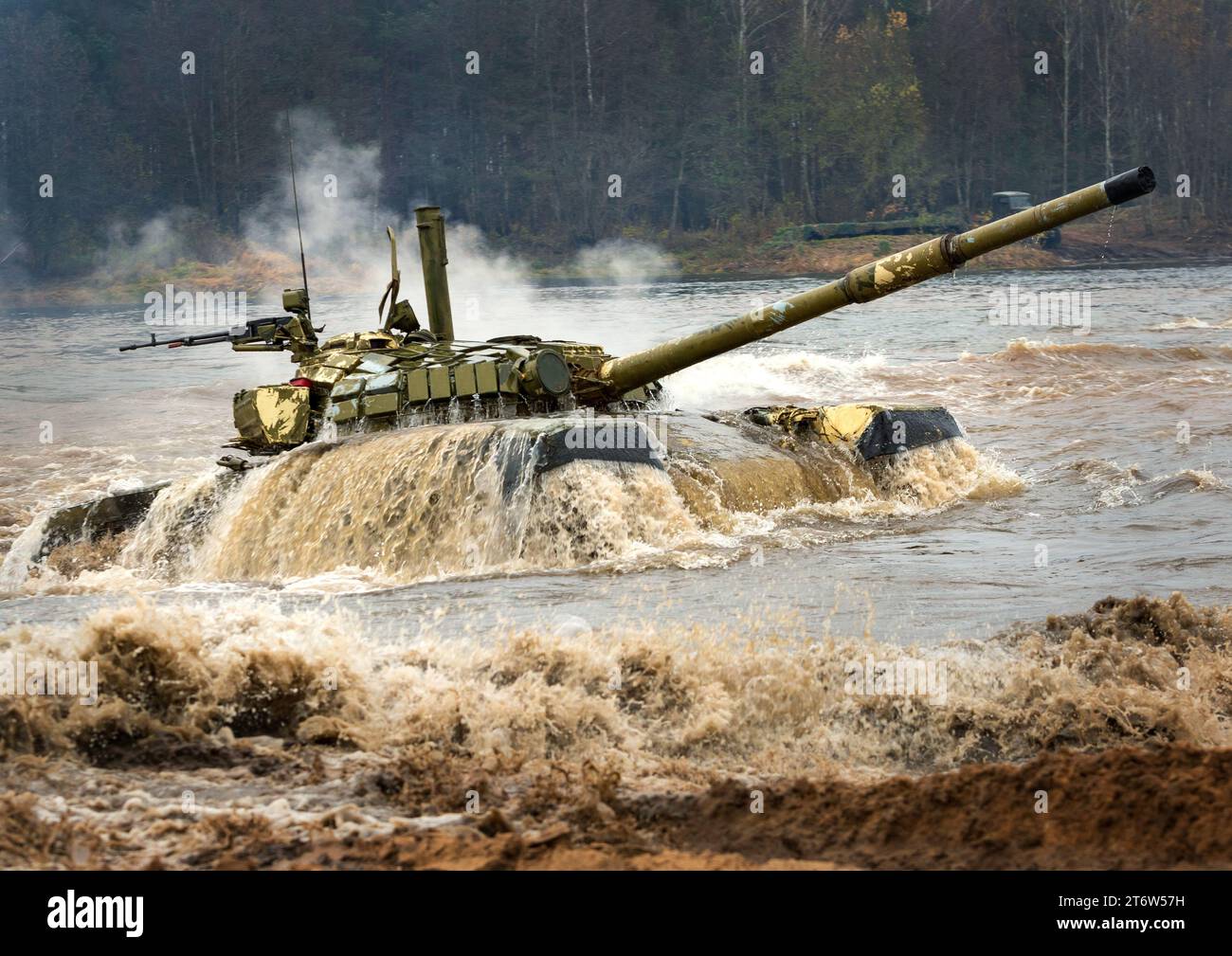 Ein mächtiger Tank für schwere Kampffahrzeuge verlässt das Flussufer, nachdem er eine Wasserbarriere entlang des Bodens gedrückt hat Stockfoto