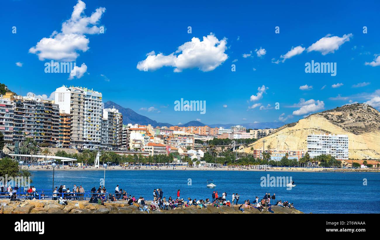 Alicante, Spanien, Eine Gruppe von Menschen in den Felsen des Uferviertels, die den Abgang des Ocean Race beobachten. Teil des Stadtbildes und des Skylins Stockfoto