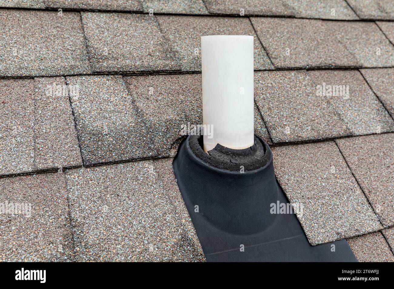 Alte Schutzmanschette der Entlüftungsleitung auf dem Dach des Hauses. Dachreparatur, Hauswartung und Hausinspektionskonzept. Stockfoto