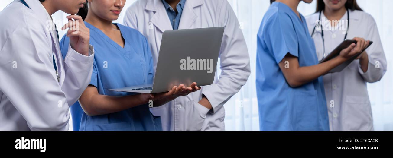 Medizinisches Team mit Ärzteschwester und Spezialisten im Gesundheitswesen arbeiten im Krankenhaus mit Laptop und Tablet zusammen. Medizinischer Arbeitsplatz und Stockfoto