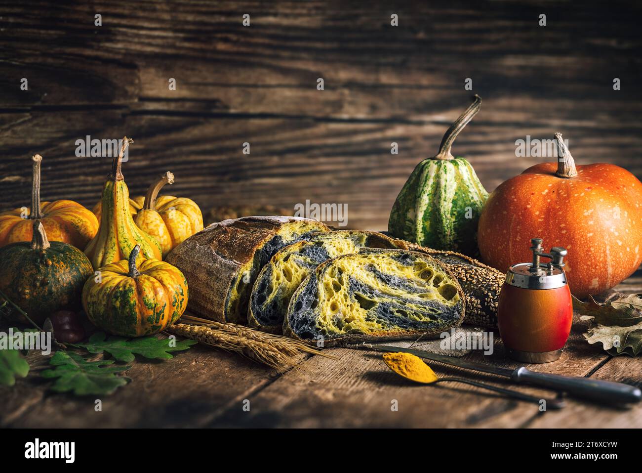 Hausgemachte knusprige Sauerteigbrotbackofen mit Weizen, Aktivkohle, Kürbis und Kurkuma-Gewürzen und würzen Herbstkost in rustikaler Küche Stockfoto