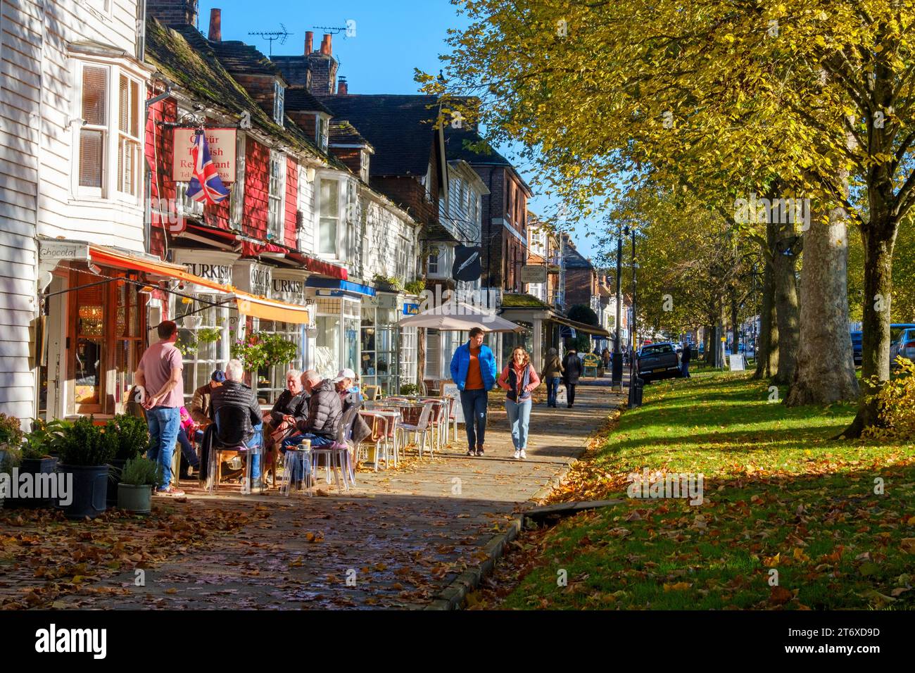 Tenterden High Street, von Bäumen gesäumter breiter Bürgersteig mit Geschäften und Cafés, an einem sonnigen Herbsttag, Kent, Großbritannien Stockfoto