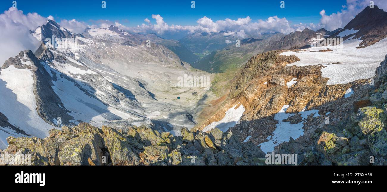Panoramablick von einem Sattel in das hochgebirgige Land der italienischen Alpen in der Nähe von Tures. Bergkamm, der zu einem Gipfel und mehreren Gletschern führt. Stockfoto