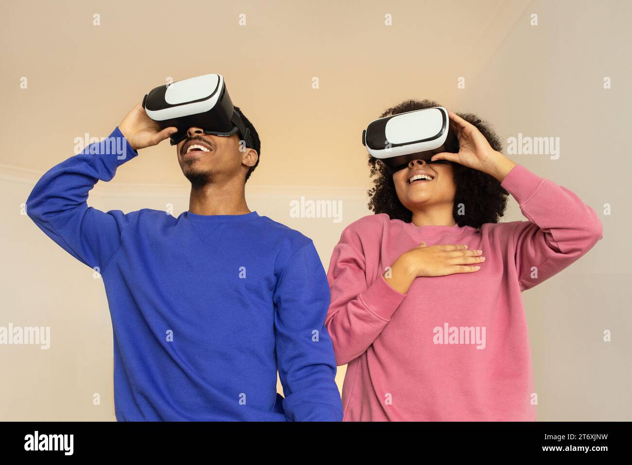 Schwarzes Paar im virtuellen Reich, das Videospiele mit Headsets in Innenräumen spielt Stockfoto