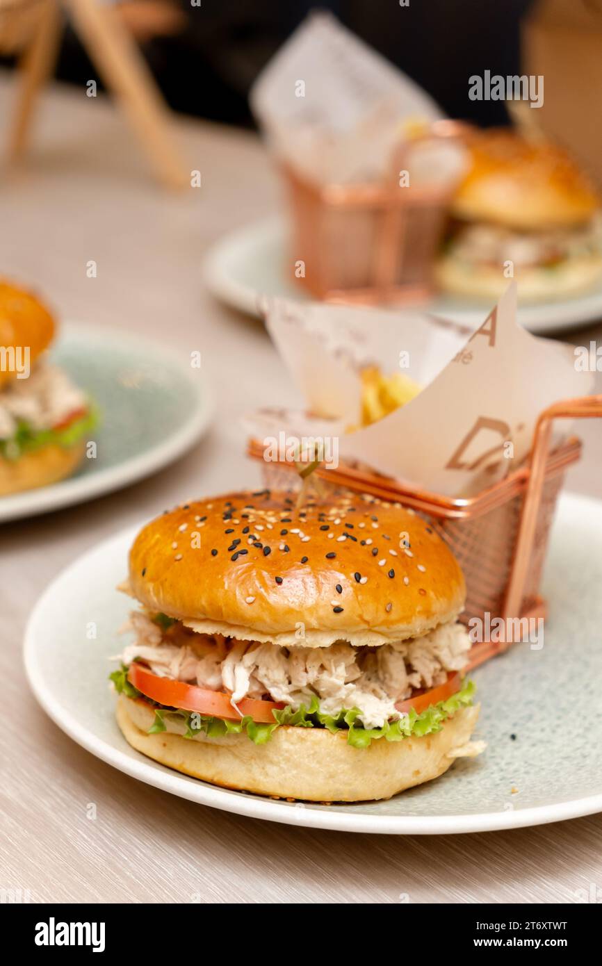 Zwei Hamburger-Teller mit einem Hamburger mit Fleisch, der andere nur mit einem Brötchen Stockfoto