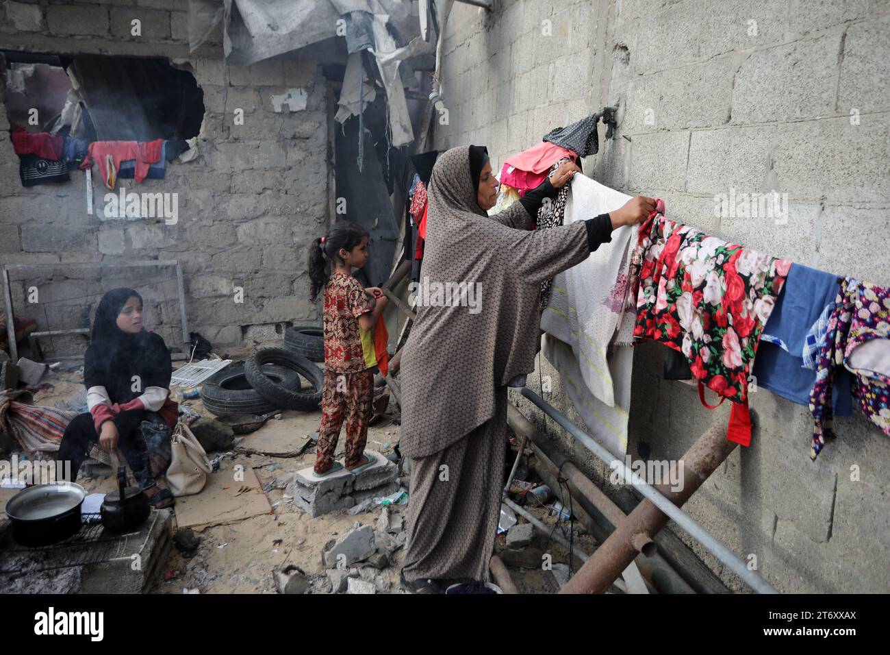 Rafah, Gaza. November 2023. Amal al-Robayaa 44, verbreitete die Kleidung in den Ruinen des Familienhauses, das bei einem israelischen Streik in Rafah im südlichen Gazastreifen am Sonntag, den 7. November 2023 zerstört wurde. Robayaa sagt, dass der Wohnblock, in dem er lebte, am 7. Oktober, dem ersten Tag des Krieges in Gaza, durch einen israelischen Bombardement zerstört wurde. Amal Rabayaa, Ehemann von Imad, versickert nun mit anderen Familienmitgliedern in einer UN-Schule in Rafah, kehrt aber am Morgen in ihr Zuhause zurück und stellt sich dem täglichen Kampf um Nahrung und Wasser. Foto: Ismael Mohamad/UPI Credit: UPI/Alamy Live News Stockfoto