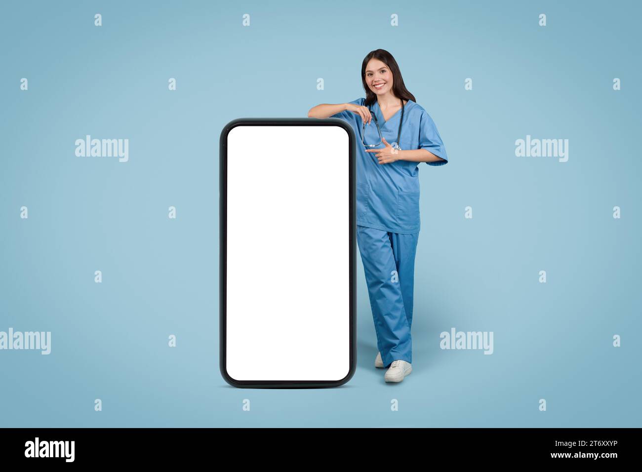 Die weibliche Schwester zeigt auf einen leeren Telefonbildschirm Stockfoto