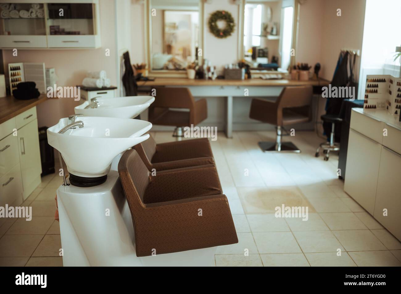 Moderner Schönheitssalon mit Stühlen, Spiegel und Waschanlage. Stockfoto