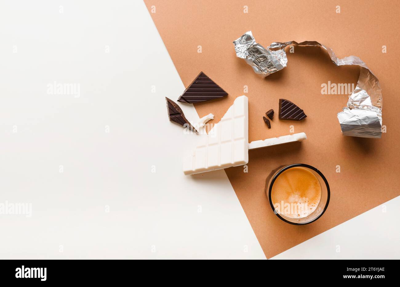 Gebrochene dunkle weiße Schokoladentafeln mit Hintergrund aus Kaffeeglas Stockfoto