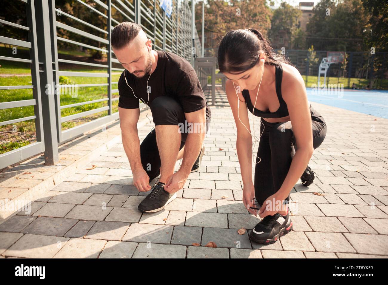 Freunde beim Outdoor-Training binden ihre Schnürsenkel Stockfoto