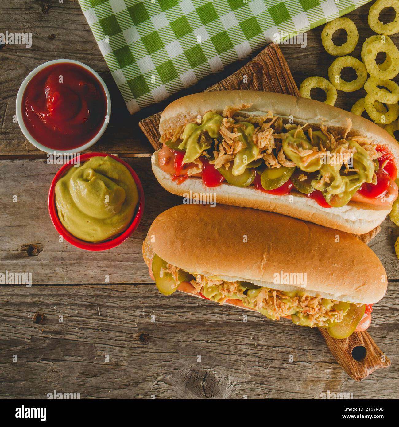 Leckere Hot Dogs mit Soßen, Zwiebelringen Stockfoto