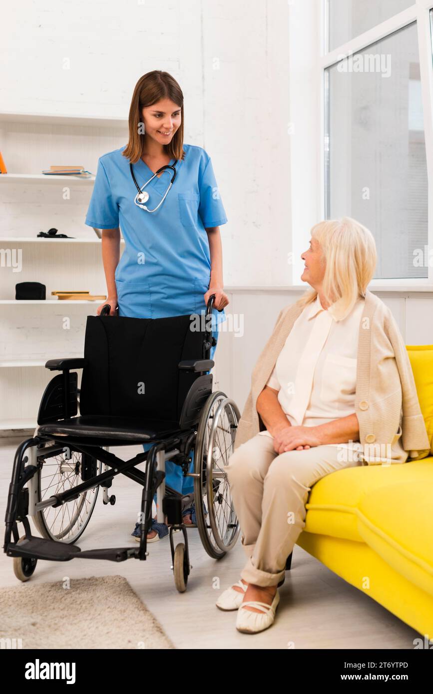 Krankenschwester, die Rollstuhlfahrerin Stockfoto