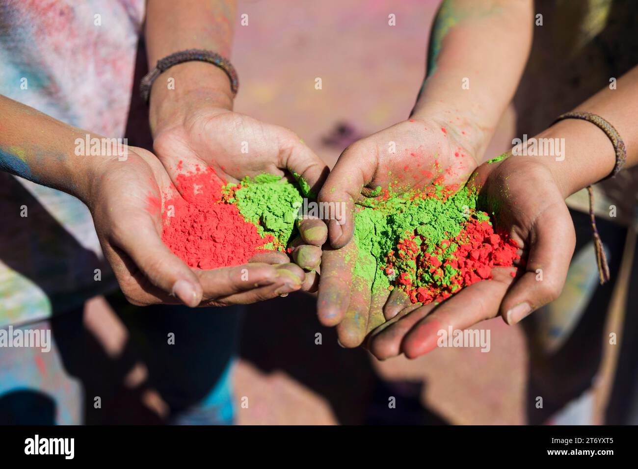 Die Damenhand hält rote grüne holi-Farben Stockfoto