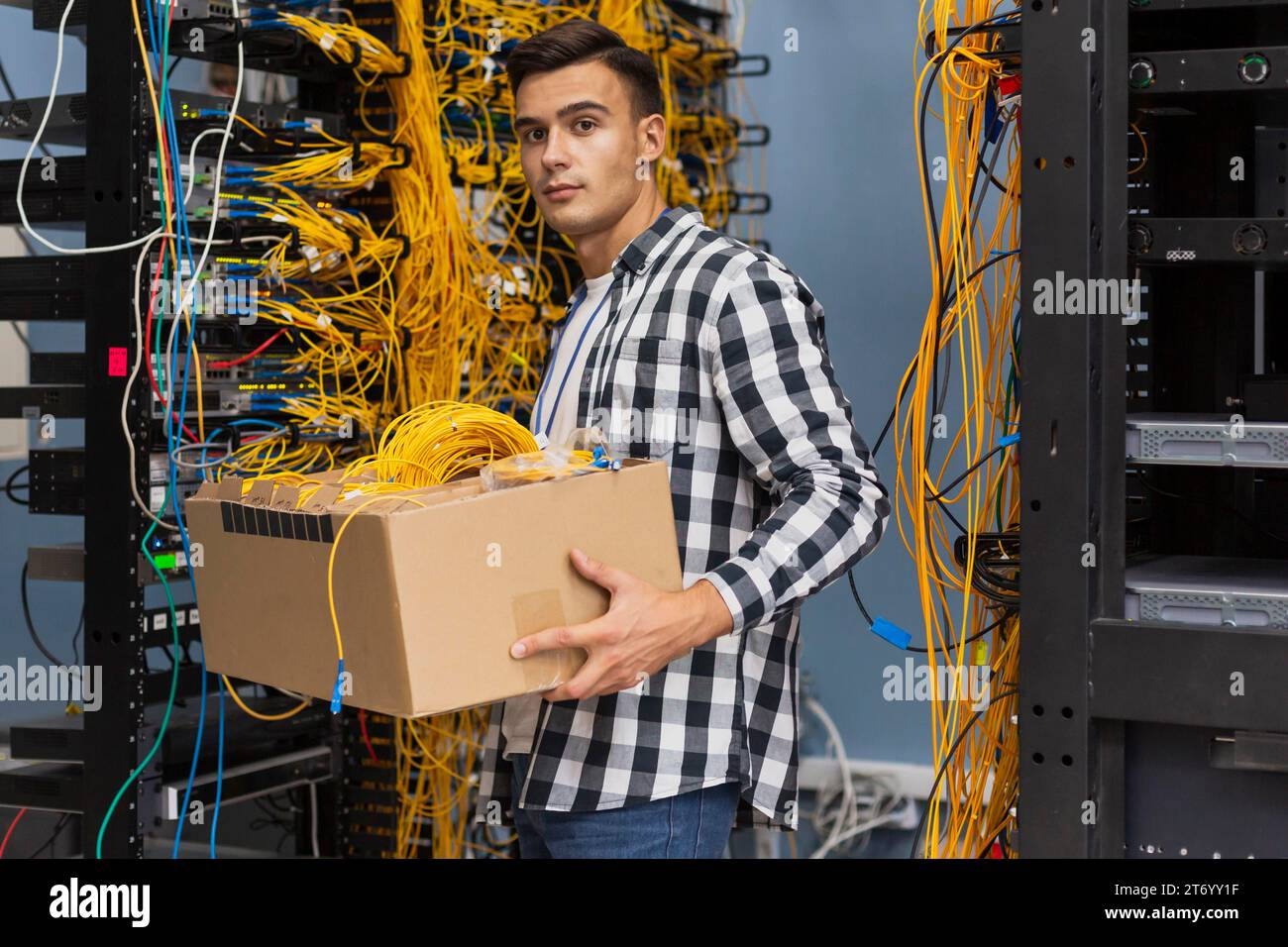 Junger Mann, der eine Kiste mit Drähten hält Stockfoto