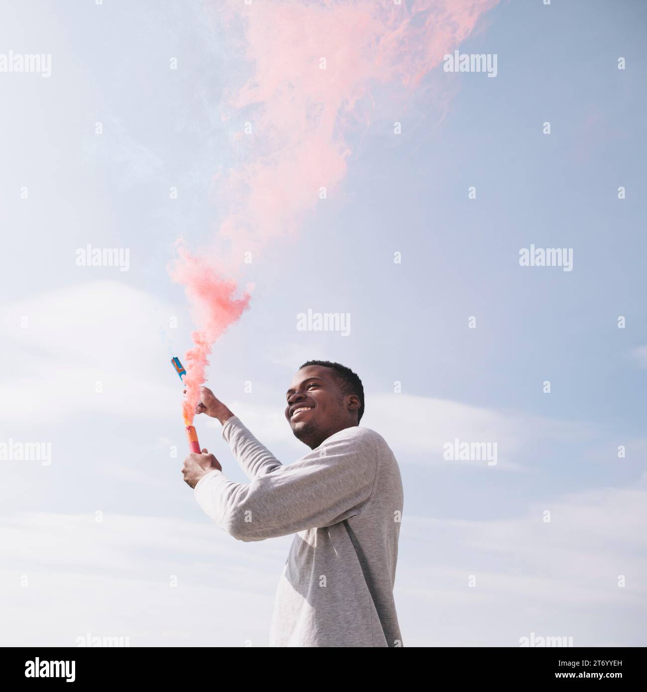 Schwarzer Mann mit roten Rauchbomben Stockfoto