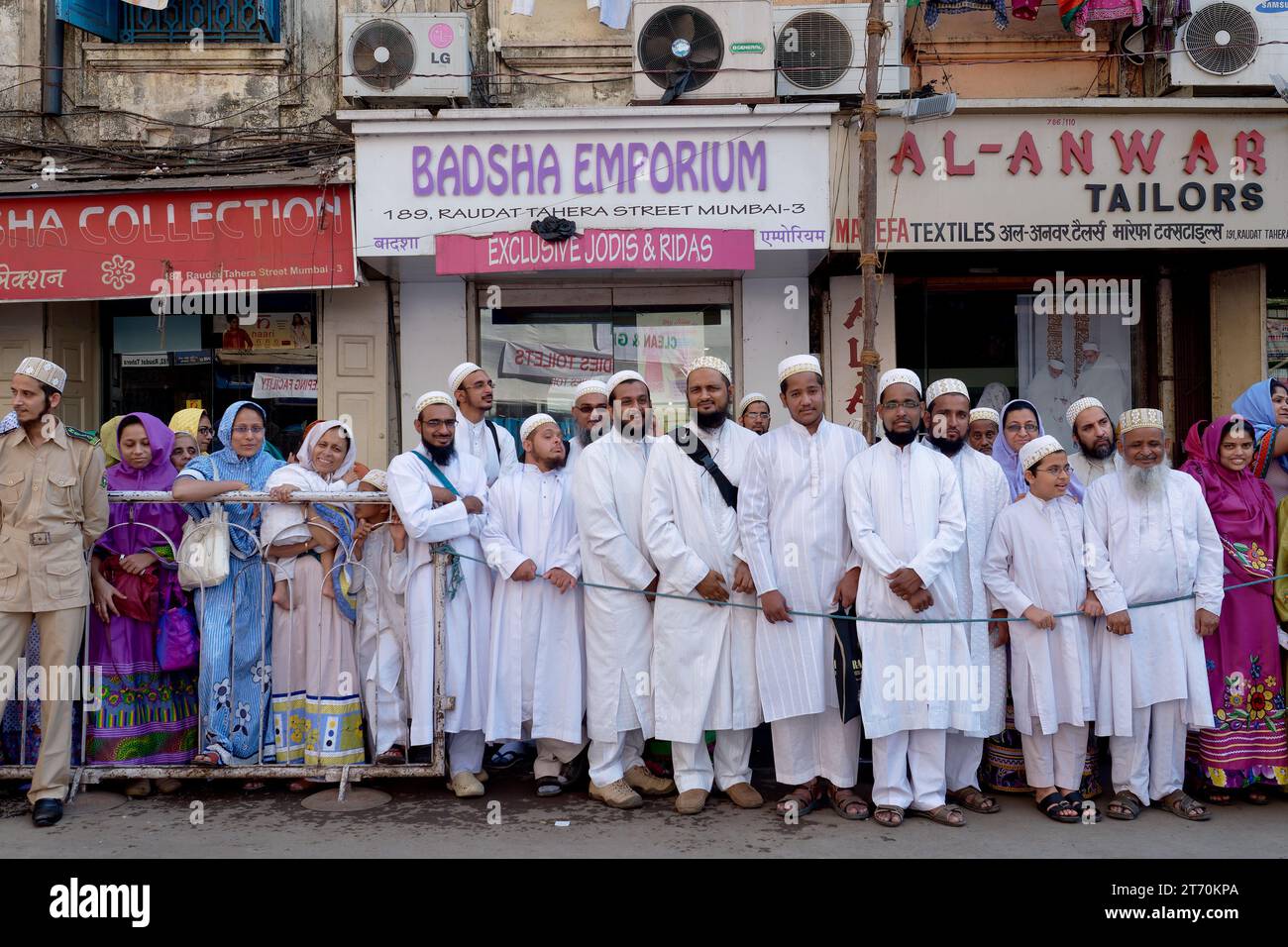 Eine große Gruppe von Bohra-Muslimen, Männer und Frauen, die Männer in traditioneller weißer Kleidung, im von Muslimen dominierten Bhendi Bazar Gebiet, Mumbai, Maharashtra Indien Stockfoto