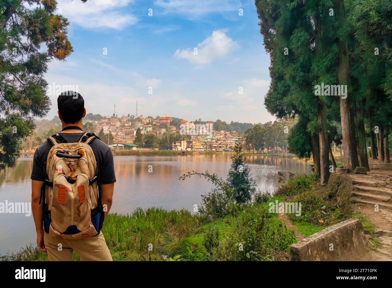 Rucksacktouristen genießen den Blick auf den malerischen Mirik Lake mit Stadtbild in Darjeeling, Indien. Stockfoto