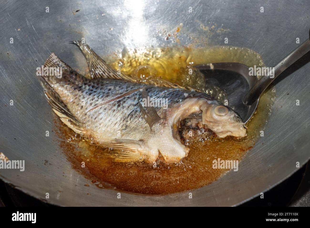 Tilapia-Fisch wird in Öl in einer Pfanne gebraten Stockfoto