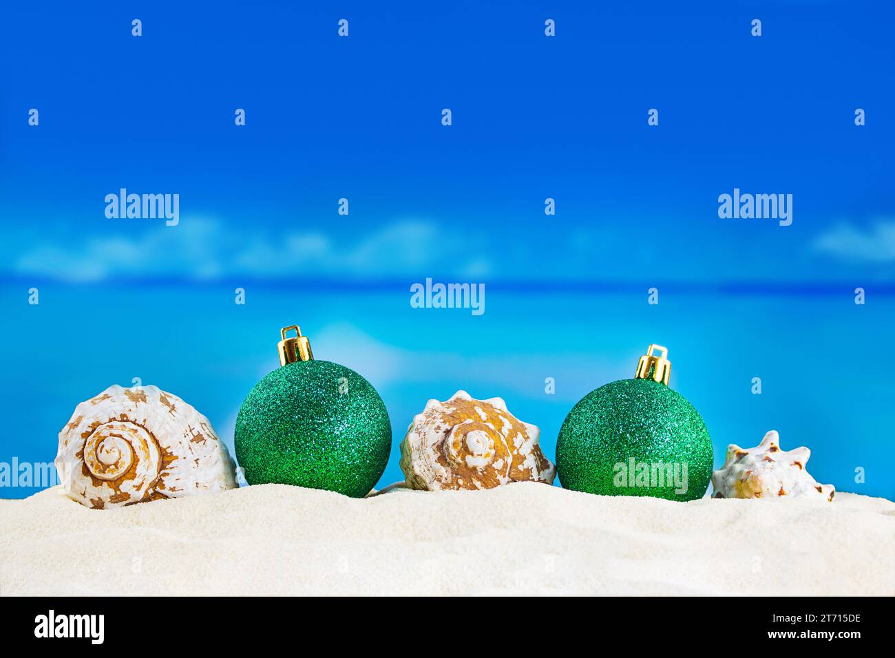 Glänzende grüne Kugeln mit Muscheln auf Sand am Strand. Weihnachten, Neujahr. Copy spaceShiny grüne Kugeln mit Muscheln auf Sand des Strandes. Weihnachten, New Ye Stockfoto