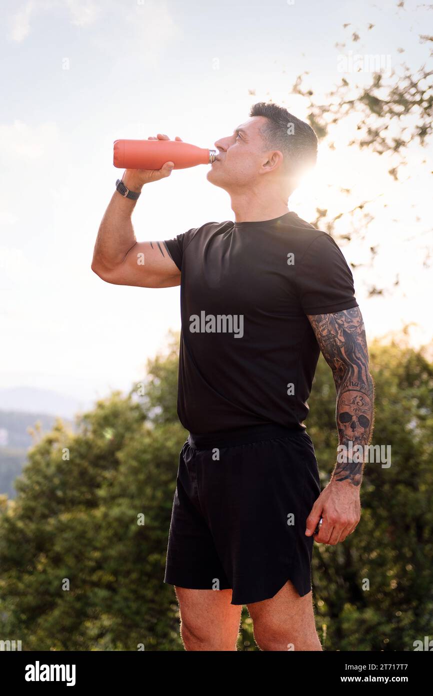 Ein Mann trinkt Wasser während ihres Trainings Stockfoto