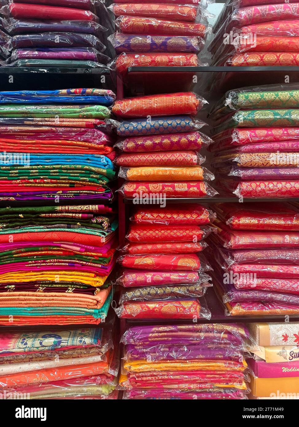 Diese exquisiten, teuren Saris sind in einem Textilgeschäft in verschiedenen Regalen angeordnet und berühmt für ihren Gold- und Silberzari und Brokat. I Stockfoto