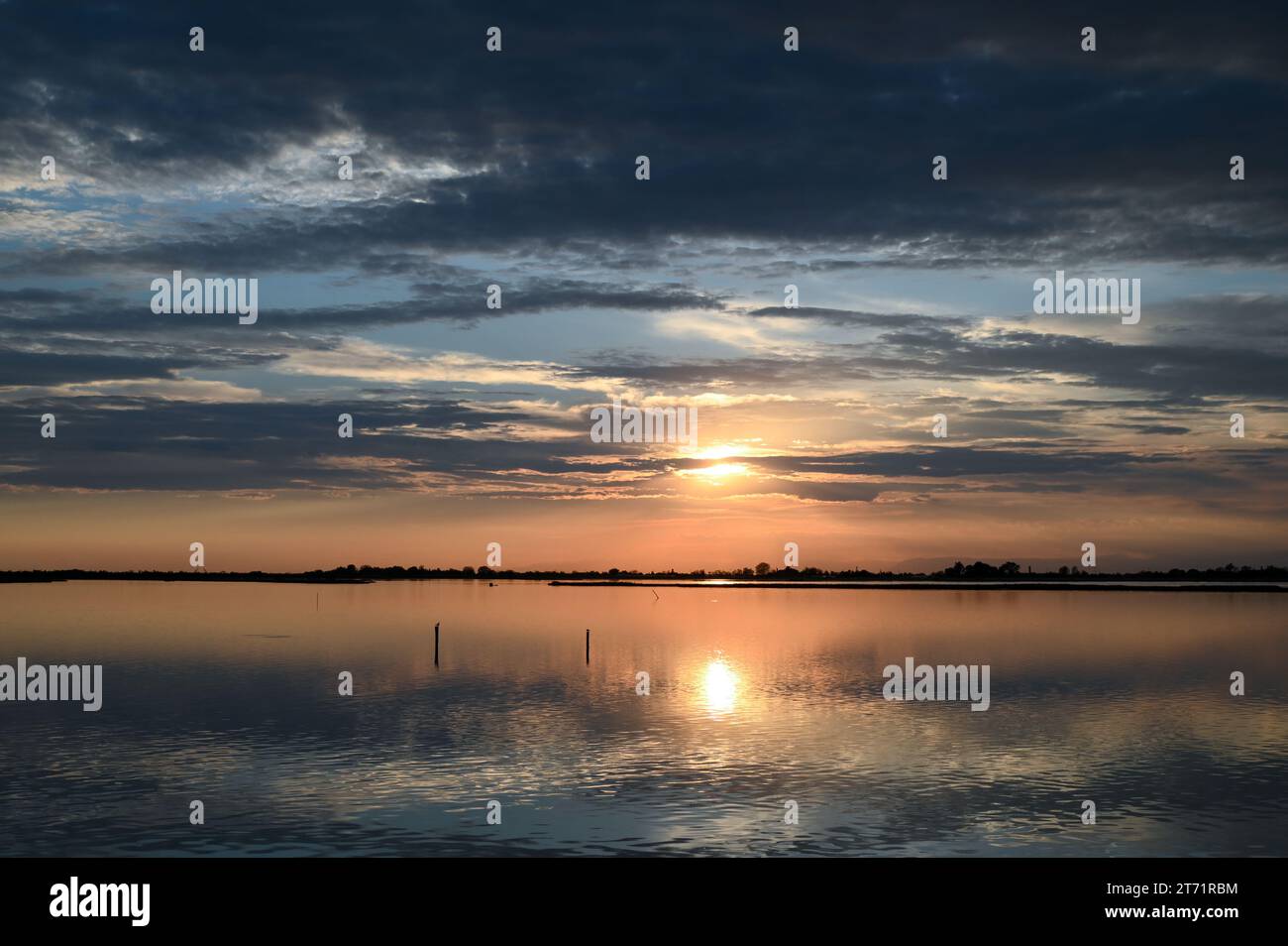 Malerische, ruhige Lagune mit stillen Wasser, die Wolken am Himmel während des Sonnenuntergangs in Venedig reflektiert Stockfoto