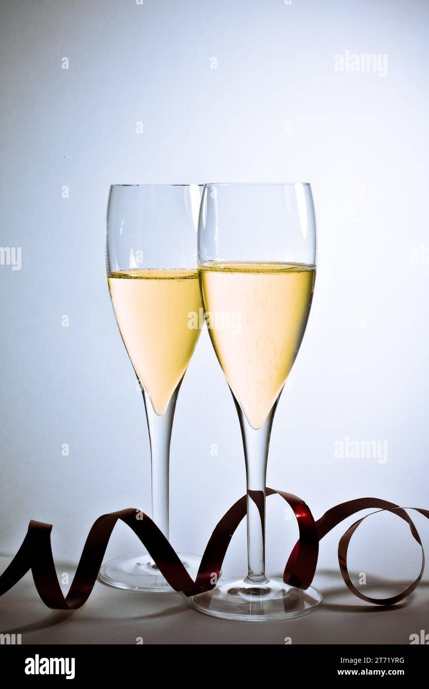 Detail der Gläser des Champagners und der weihnachtsdekoration auf weißem Hintergrund; Detail der Gläser des Champagners und der weihnachtsdekoration auf weißem Hintergrund Stockfoto