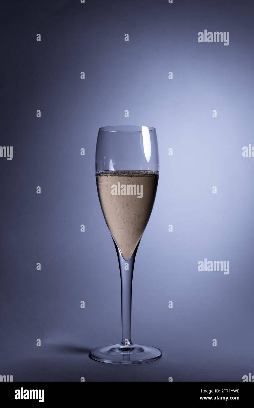 Nahaufnahme eines Glases Champagner auf hellblauem Hintergrund; Nahaufnahme eines Glases Champagner auf hellblauem Hintergrund Stockfoto