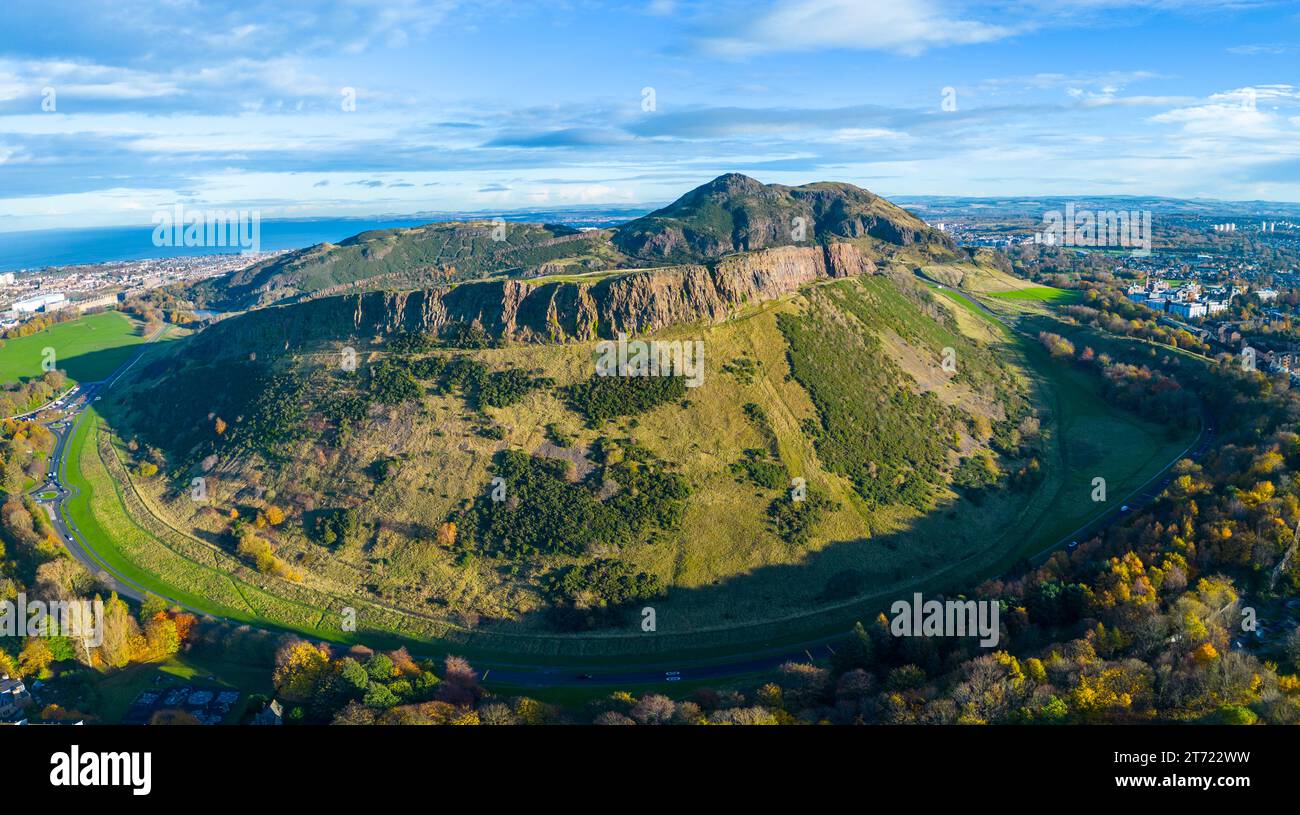 Luftaufnahme der Salisbury Crags mit Arthurs Sitz nach hinten im Herbst im Holyrood Park, Edinburgh, Schottland, Großbritannien Stockfoto
