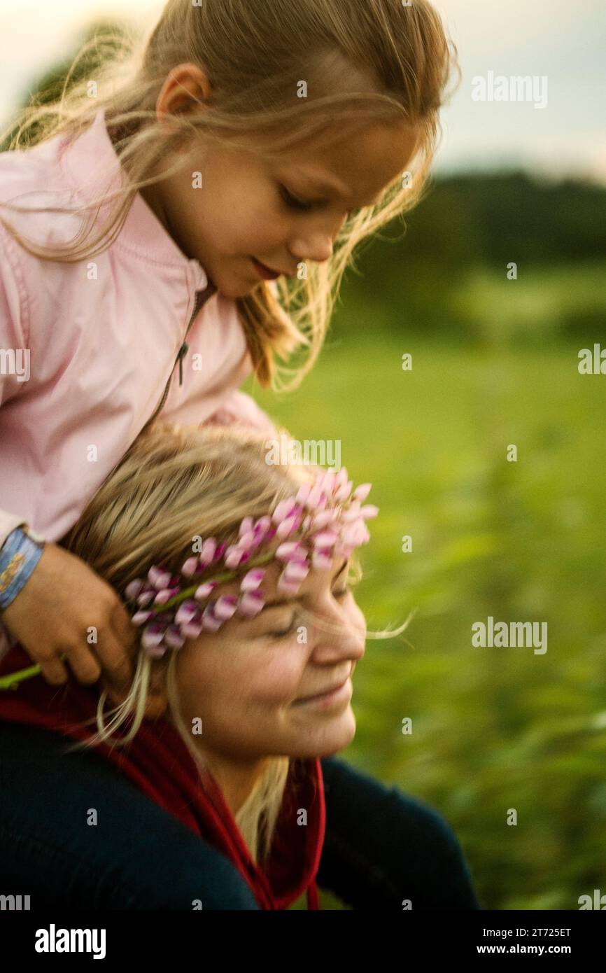 Mädchen mit rosa Blumen und ihrer lächelnden Schwester Stockfoto