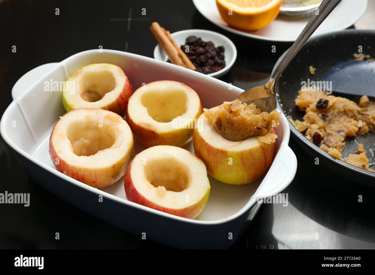 Äpfel werden mit einer Mischung aus Mandeln und Honig gefüllt und dann im Ofen gebacken, Winterdessert für Feiertage wie Thanksgiving, Weihnachten und Neuheiten Stockfoto