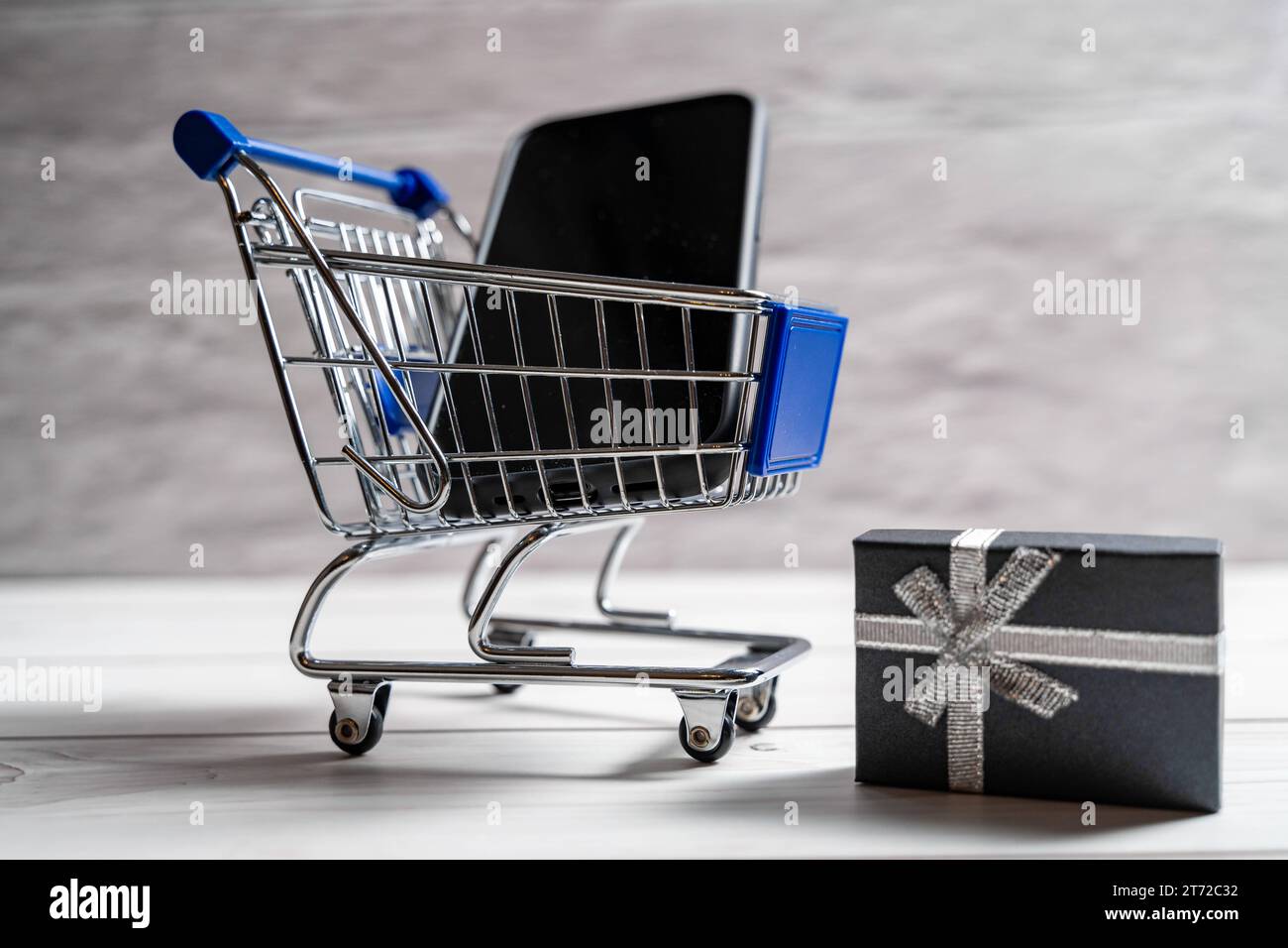 Bayern, Deutschland - 10. November 2023: Ein neues Smartphone im Miniatur-Einkaufswagen. Handy- und Technologiekonzept *** ein neues Smartphone in einem Miniatur-Einkaufswagen. Kaufen von Handy und Technik Konzept Credit: Imago/Alamy Live News Stockfoto